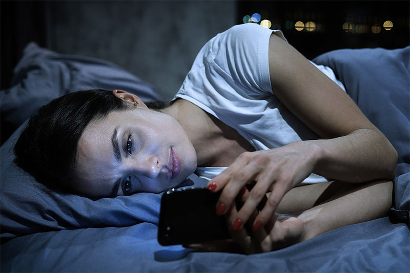 Screens smartphone in bed